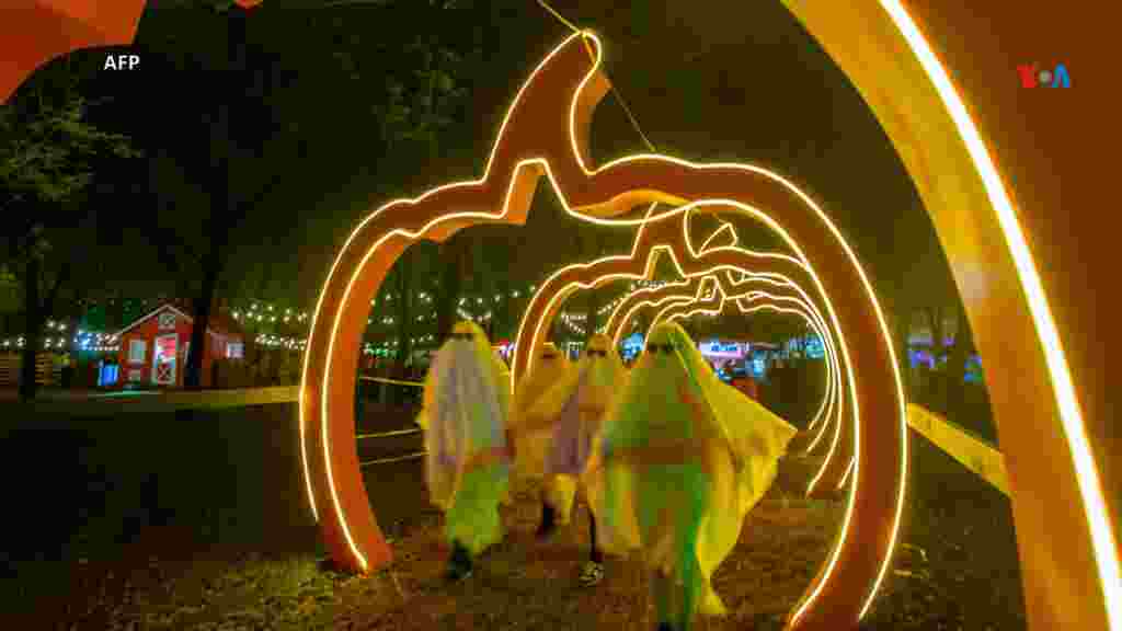 Personas disfrazadas de fantasmas caminan durante el Festival de la Calabaza en el Parque Fundidora en Monterrey, estado de Nuevo León, México.