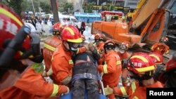 8일 중국 남동부 푸젠성 취안저우의 호텔 붕괴 현장에서 구조대원들이 부상자를 구조하고 있다.