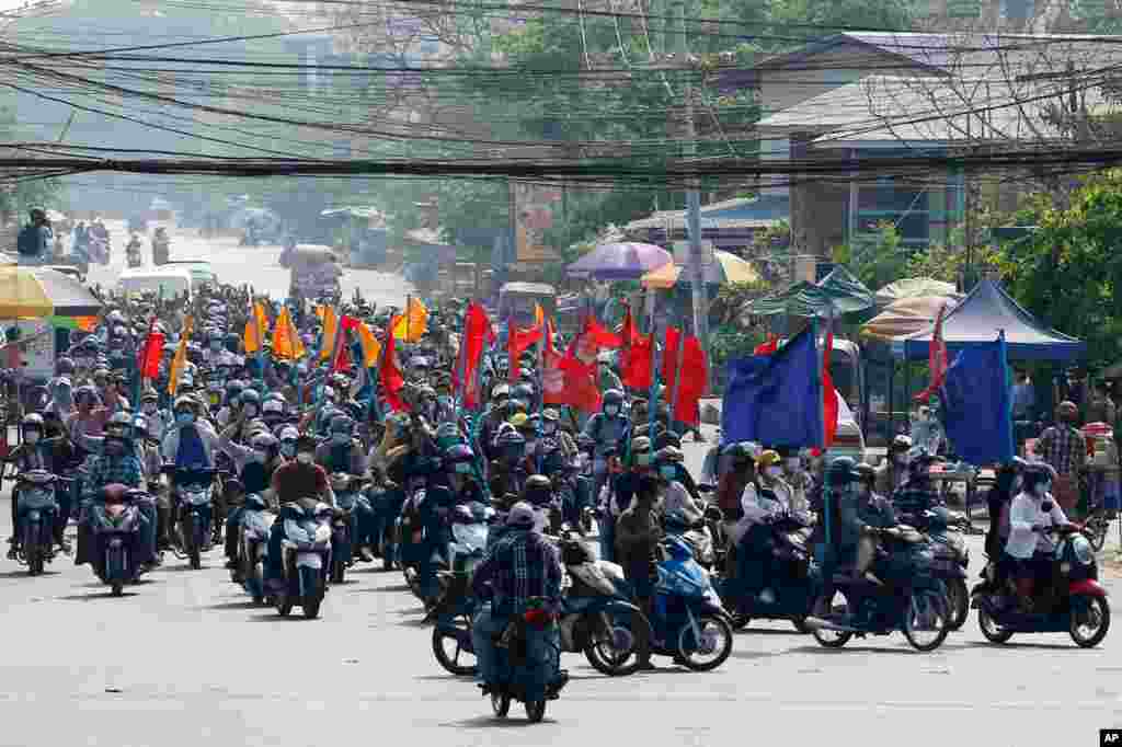 Protesters carry flags as they drive their motorcycles during an anti-coup protest in Mandalay, Myanmar.