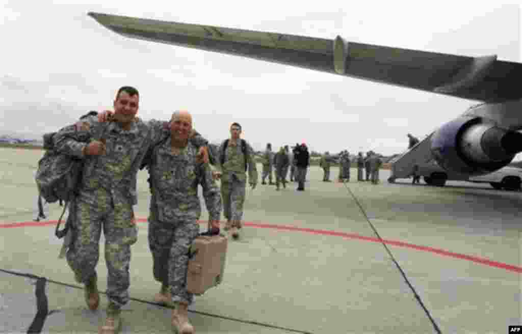 Sgt. Jared Doohen of Georgia, Vt., left, and Staff Sgt. Thomas Stanley of Montgomery, Vt. celebrate their return during a homecoming for Vermont National Guard troops on, Monday, Nov. 22, 2010 in South Burlington, Vt. Forty soldiers returned to the state 