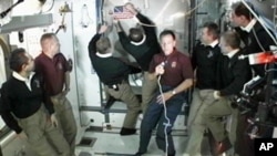 The members of the STS-135 and Expedition 28 crews participate in a farewell ceremony aboard the International Space Station in preparation for the closure of hatches between the orbital complex and space shuttle Atlantis, Jul 18, 2011