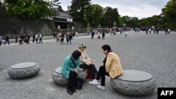 Para pengunjung berbincang di halaman Istana Kekaisaran di Tokyo, 29 April 2019, sehari sebelum upacara turun takhta Kaisar Jepang Akihito.
