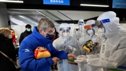 Presiden Komite Olimpiade Internasional (IOC) Thomas Bach memberikan suvenir kepada para petugas restoran saat ia mengunjungi area khusus Olimpiade Musim Dingin Beijing, pada 1 Februari 2022. (Pool via Reuters/Wang Zhao)