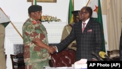 Le président du Zimbabwe Robert Mugabe serre la main du général Constantino Chiwenga avant de donner son discours à Harare, le 19 novembre 2017.