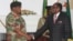 FILE: FORMER President Robert Mugabe, right, shakes hands with Army General Constantino Chiwenga before delivering his speech during a live broadcast at State House in Harare, Sunday, Nov, 19, 2017. (AP Photo)