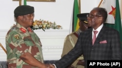 Le président zimbabwéen Robert Mugabe, à droite, serre la main au général de l'armée Constantino Chiwenga avant de prononcer son discours lors d'une émission en direct à State House à Harare, 19 novembre 2017.