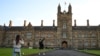 FILE - Two students from China take photos at the University of Sydney, in Sydney, Australia, Aug. 11, 2020.