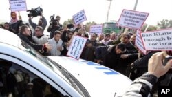 Palestinian protesters surround a vehicle in the convoy of U.N. Secretary-General Ban Ki-moon as it arrives at Erez border crossing between Israel and Gaza, February 2, 2012.