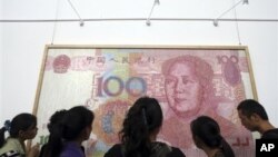 参观者在成都的展览会上观看关于人民币百元钞票的美术作品（2011年10月）