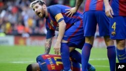 Lionel Messi s’incline pour assister son coéquipier Neymar du FC Barcelone, touché par un projectile lancé par un spectateur lors du match de la Liga espagnole entre Valence et le FC Barcelone au stade Mestalla à Valence, Espagne, le 22 octobre 2016.