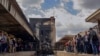 Policemen guard the accident site as investigators arrive to inspect the scene for clues on why the locomotive, which crashed at high speed, failed to stop. (H. Elrasam/VOA) 