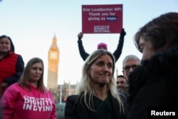 Para pengunjuk rasa menunjukkan plakat di depan Parlemen di London, Jumat, 29 November 2024 saat anggota parlemen Inggris memberikan persetujuan awal terhadap RUU Eutanasia. (Alberto Pezzali/AP)