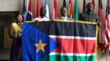 From left, Regina Onyeibe, Africa liaison for Dallas, Dallas-area resident Michael Majok, Dallas City Councilman Dwaine Caraway and pro basketball star Luol Deng participate in the raising of the South Sudanese flag at City Hall in Dallas, Texas, July 2017.