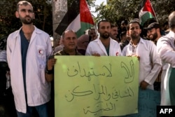 FILE - Medical workers from Princess Alia Governmental Hospital and other protesters gather for a demonstration condemning the targeting of hospitals and medical clinics in the Gaza Strip, in the city of Hebron in the occupied West Bank on October 25, 2023.