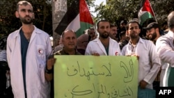 Medical workers from Princess Alia Governmental Hospital and other protesters gather for a demonstration condemning the targeting of hospitals and medical clinics and in solidarity with Palestinians in the Gaza Strip, in the city of Hebron in the occupied