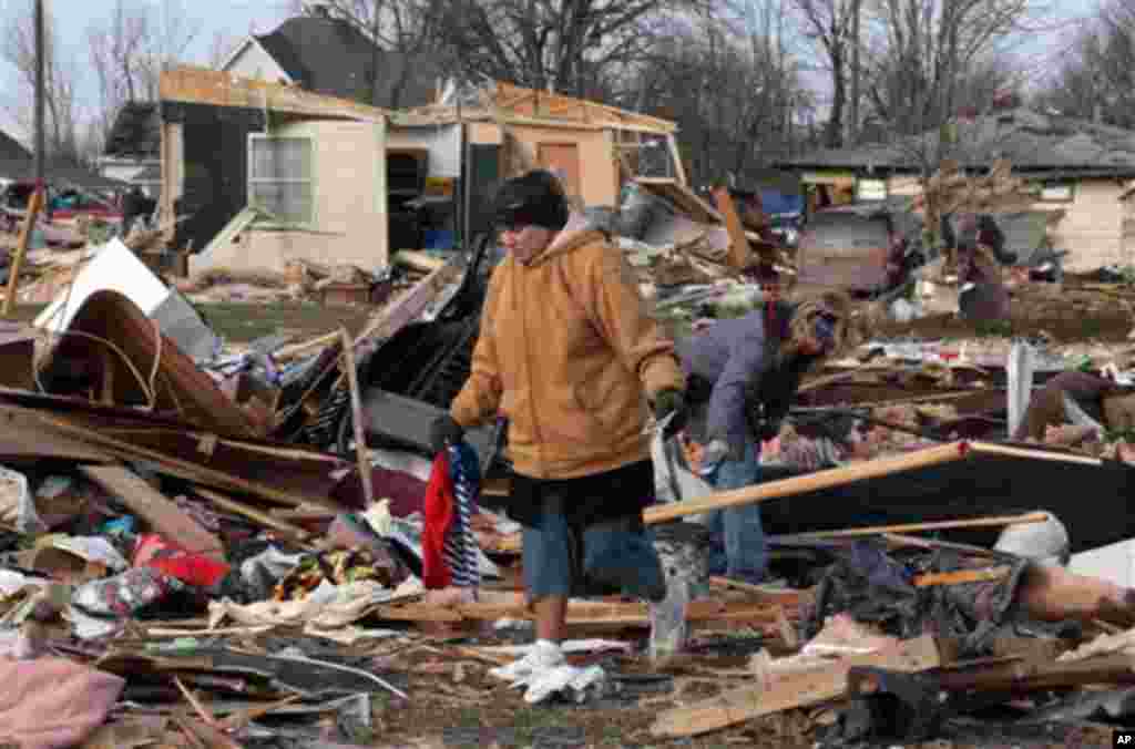 Unidentified women search through debris of Ted and Brenda Tolbert's Holton, Ind. home Sunday, March 4, 2012.