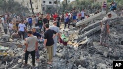 ساکنان دیرالبلح در ساختمان‌های ویران‌شده توسط حملات هوایی اسرائیل به جنوب نوار غزه، به دنبال بازماندگان می‌گردند - ۲۵ مهر ۱۴۰۲