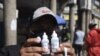 Un hombre muestra frascos de dióxido de cloro que compró en una farmacia de Cochabamba, Bolivia, para protegerse del coronavirus. Las autoridades rechazan su uso.