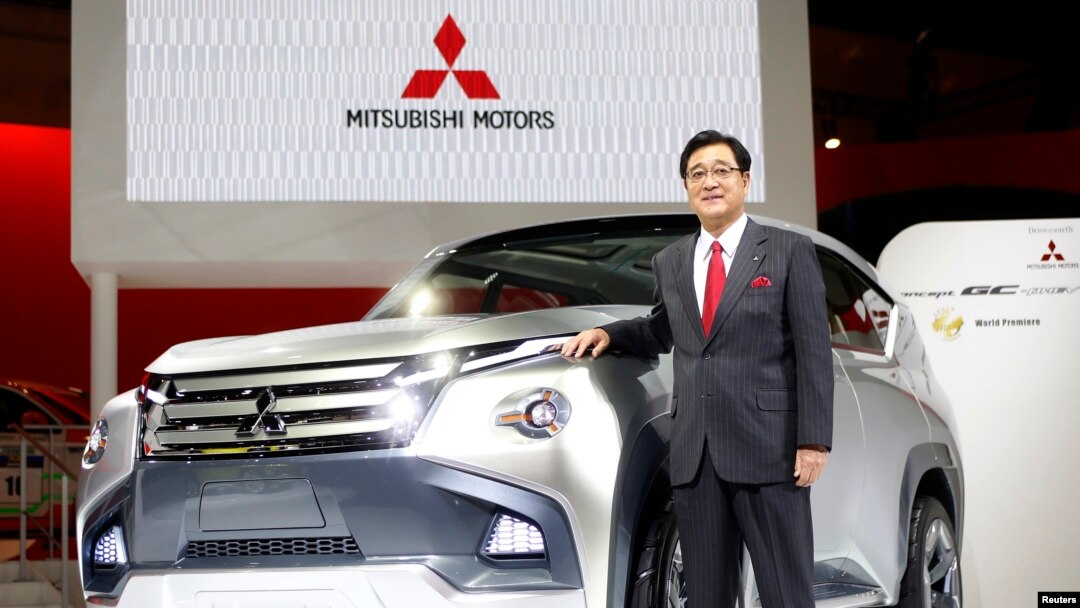Presiden Mitsubishi Motors Corp Osamu Masuko berfoto dekat mobil konsep GC-PHEV pada Tokyo Motor Show, November 2013. 
