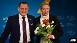 Alice Weidel, co-leader of Germany's far-right Alternative for Germany (AfD) party, holds a bouquet of flowers she was given by party co-leader Tino Chrupalla during a press conference on Dec. 7, 2024 in Berlin,