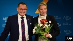 Alice Weidel, ko-liderka njemačke krajnje desničarske stranke Alternativa za Njemačku (AfD), drži buket cvijeća koji joj je poklonio ko-lider stranke Tino Chrupalla na konferenciji za novinare 7. decembra 2024. u Berlinu,