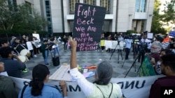 FILE - Protesters demonstrate outside the federal courthouse where a judge heard arguments over the U.S. Justice Department's request to block three California laws that extend protections to people in the country illegally, in Sacramento, Calif., June 20, 2018.