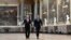 Russian President Vladimir Putin (L) looks around as he walks in the Galerie des Batailles (Gallery of Battles) as he arrives with French President Emmanuel Macron (R) for a joint press conference following their meeting at the Versailles Palace, near Par