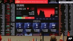 A Filipino trader looks at an electronic board showing the exchange rates and a downward graph during afternoon trading at the Philippine Stock Exchange in the financial district of Makati, south of Manila, Sept. 30, 2016.