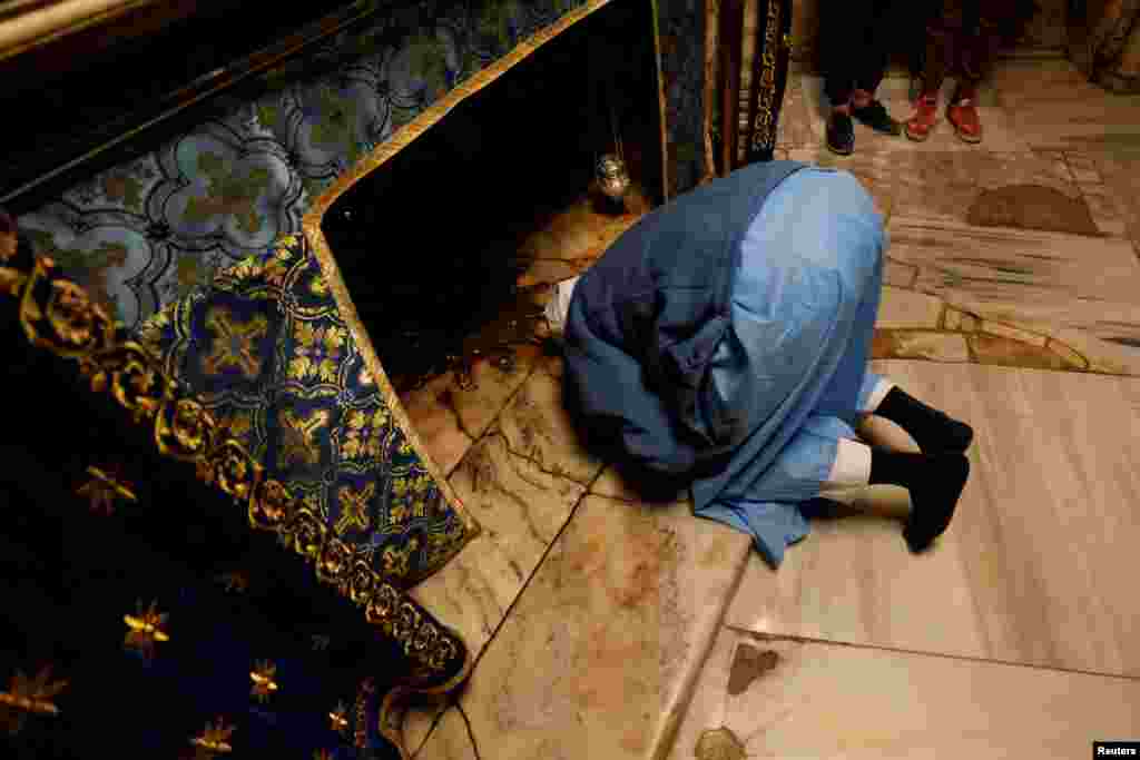 A person prays at the Church of the Nativity ahead of the arrival of the Latin Patriarch of Jerusalem, Pierbattista Pizzaballa, in Bethlehem in the Israeli-occupied West Bank.