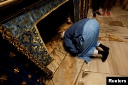 A person prays at the Church of the Nativity ahead of the arrival of the Latin Patriarch of Jerusalem, Pierbattista Pizzaballa, in Bethlehem in the Israeli-occupied West Bank, Dec. 24, 2024.