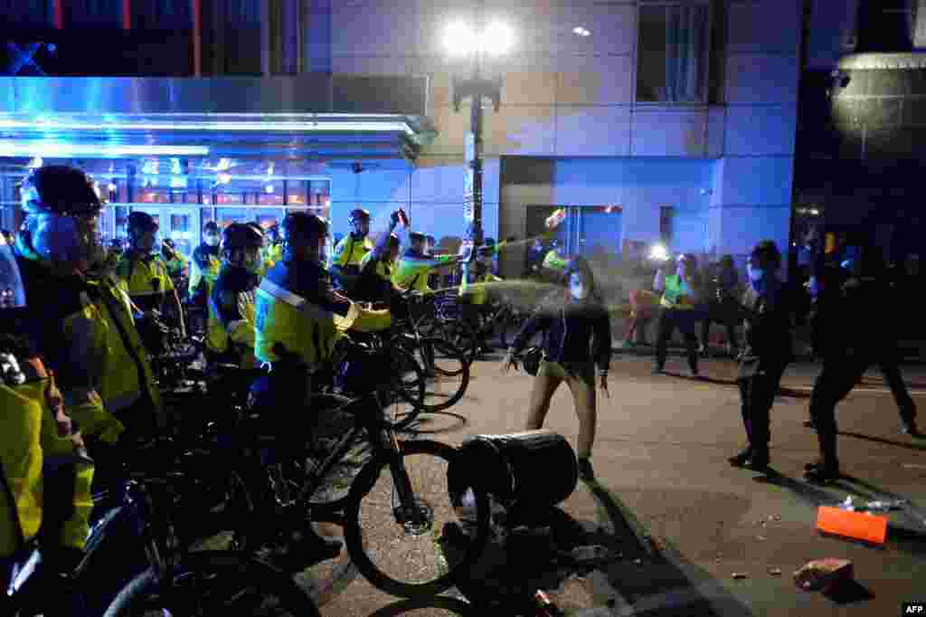 Police officers spray protesters with pepper spray during a demonstration over the death of George Floyd, an unarmed black man who died in Minneapolis Police custody, in Boston, Massachusetts on May 31, 2020. 