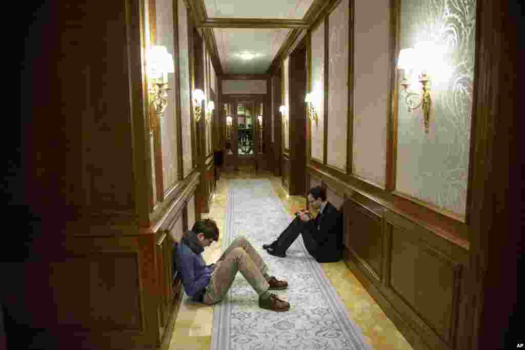 Reporters sit in a hallway during the Iran nuclear program negotiations at the Beau Rivage Palace Hotel in Lausanne, Switzerland, April 1, 2015.