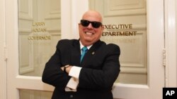 This photo provided by Office of the Maryland Governor, Maryland Gov. Larry Hogan, who has lost hair after receiving treatment for B-cell non-Hodgkin lymphoma, poses for a photograph on Tuesday, July 28, 2015 in Annapolis, Md. In a Facebook posting, Hoga