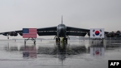 Национальные флаги США и Южной Кореи перед стратегическим бомбардировщиком B-52H, на базе южнокорейских ВВС в аэропорту Чхонджу, 19 октября 2023 года.
