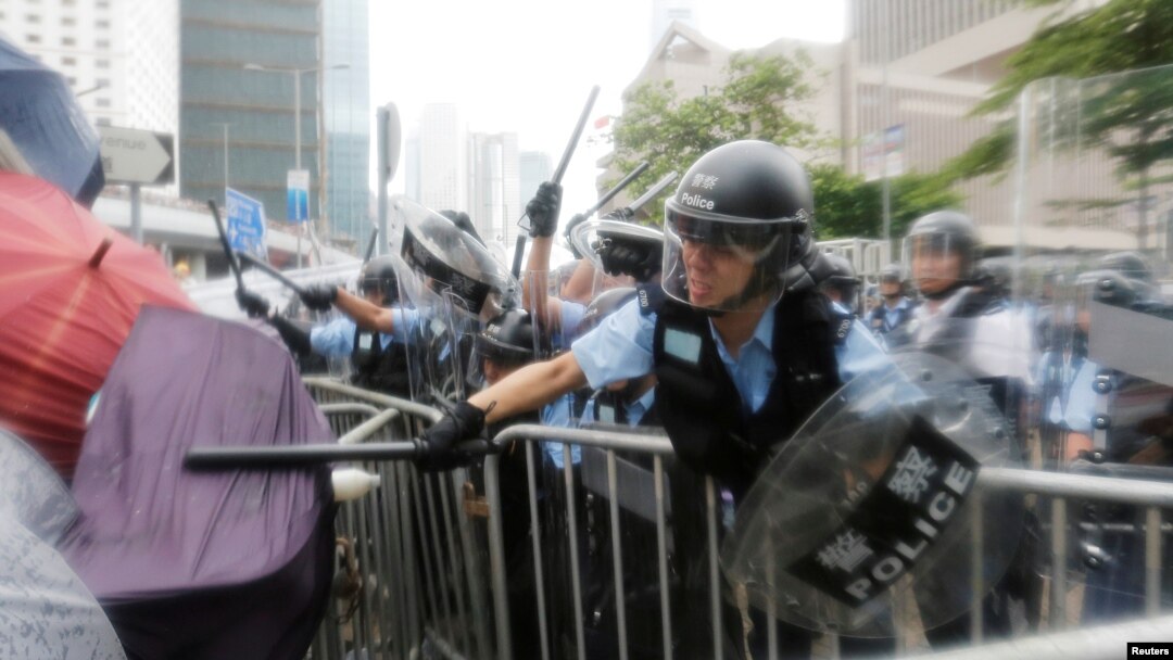 Waandamanaji wakikabiliana na polisi wa kuzuia ghasia wakati wa maandamano ya kupinga pendekezo la sheria ya kuwarudisha raia kujibu mashtaka nchini kwao karibu na bunge la Hong Kong, China Juni 12, 2019. REUTERS/Thomas Peter