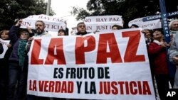 FILE - Lay members of the Catholic Church carry a sign that reads in Spanish "Truth and justice bear peace" after a mass of reconciliation at a cathedral in Osorno, Chile, June 17, 2018.