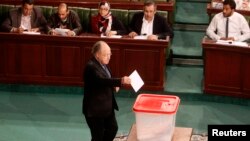 FILE - Tunisia's Speaker of the Assembly Mustapha Ben Jaafar casts his vote over the composition of an election commission that will oversee a vote later this year, Tunis, Jan. 8, 2014.