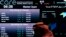 FILE - A Saudi man looks at stocks at the Tadawul Saudi Stock Exchange, in Riyadh, Saudi Arabia, June 15, 2015.