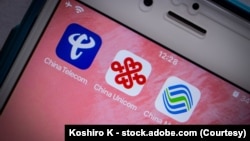 资料照片：iPhone上中国三大移动通信运营商--中国电信、中国联通和中国移动的图标。(2021年3月10日)