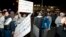 Demonstrators carry placards during a protest in Kuwait City, January 6, 2013.