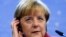 Germany's Chancellor Angela Merkel adjusts her headset during a news conference at a European Union leaders summit in Brussels Oct. 25, 2013.