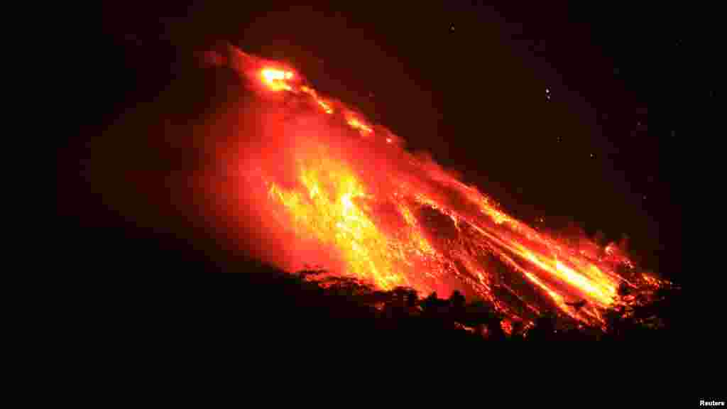 Volcano Mount Karangetang spews lava as seen from Bebali village in Siau district of Indonesia&#39;s North Sulawesi province, Apr. 4, 2013.