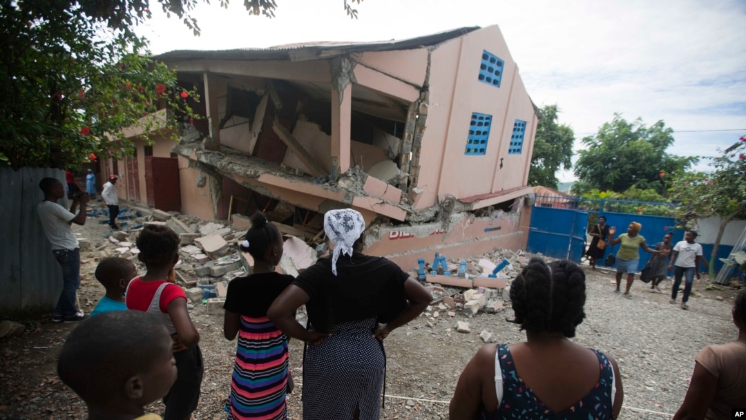 Warga di lokasi sekolah yang rusak akibat gempa berkekuatan 5,9 SR di Gros Morne, Haiti, 7 Oktober 2018. 