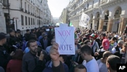 An Algerian demonstrator holds a sign that reads "no vote" during a protest against the government and the upcoming presidential elections in Algiers, Algeria, Nov.29, 2019. Thousands of protesters took to the streets of the capital after Friday prayer.