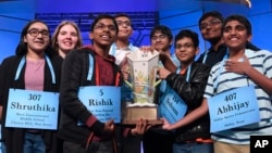 Co-champions of the 2019 Scripps National Spelling Bee, from left, Shruthika Padhy, Erin Howard, Rishik Gandhasri, Christopher Serrao, Saketh Sundar, Sohum Sukhatankar, Rohan Raja and Abhijay Kodali hold the trophy in Oxon Hill, Md., May 31, 2019.