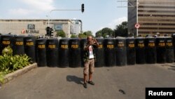 Seorang pria menggunakan ponsel dalam aksi massa menyusul penetapan hasil pilpres. Aksi masa berlangsung dekat kantor Badan Pengawas Pemilihan Umum (Bawaslu) di Jakarta, Indonesia, 22 Mei 2019. (Foto: Reuters/Willy Kurniawan)