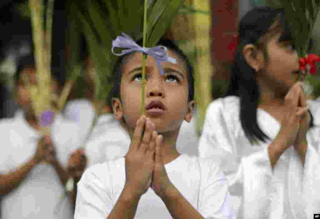 A Filipino boy participates in Palm Sunday rites outside the Holy Family Parish Church in Quezon city, north of Manila, Philippines.