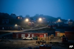 FILE - Early morning fog shrouds homes in Kulusuk, Greenland, Aug. 15, 2019. The Arctic is taking on new geopolitical and economic importance, and not just the United States hopes to stake a claim, with Russia, China and others all wanting in.