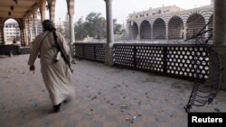 Một chiến binh phe nổi dậy trong đền thờ Khalid ibn al-Walid, bị hư hại vì giao tranh