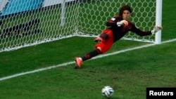 Mexico's Guillermo Ochoa goes the wrong way as Klaas-Jan Huntelaar (unseen) of the Netherlands scores on a decisive penalty kick at the Castelao arena in Fortaleza, June 29, 2014.